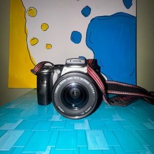 Canon Digital Camera within Black Body and Red Strap doesn’t come with battery